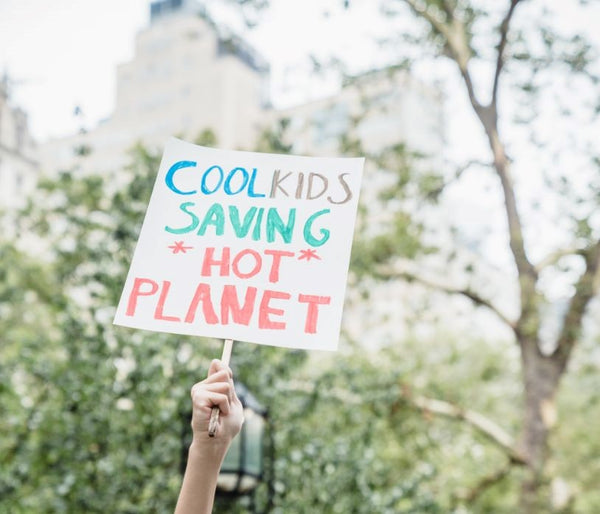 Cartello con scritta in inglese "Cool Kids saving hot Planet"