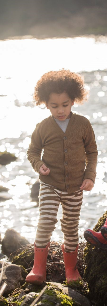 Bambino indossa cardigan bronzo e leggings a righe panna e bronzo