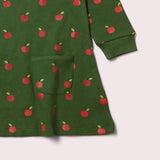 dettaglio vestito bambina verde con mele rosse e taschino