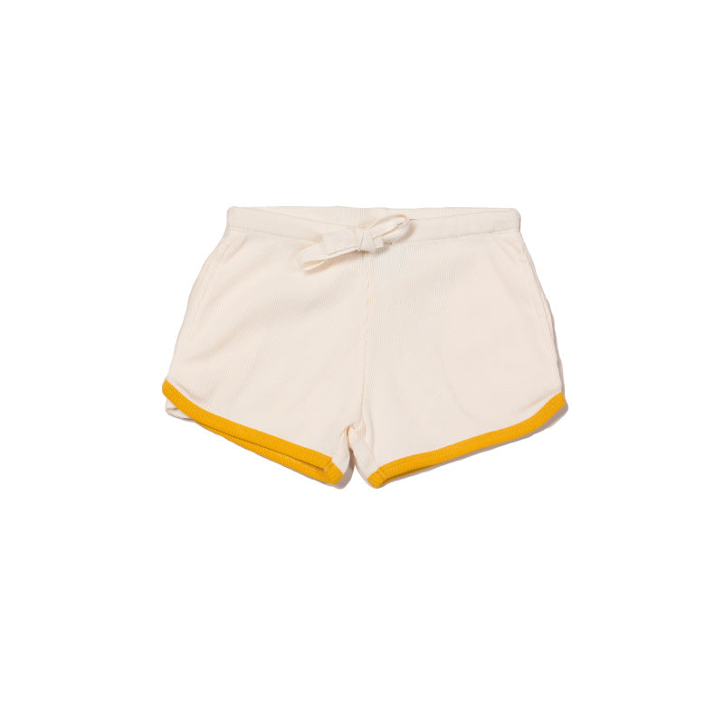 pantaloncino color crema a coste con bordo a contrasto giallo su sfondo bianco