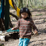 bambina indossa maglione marrone con volpi e pantaloni azzurri