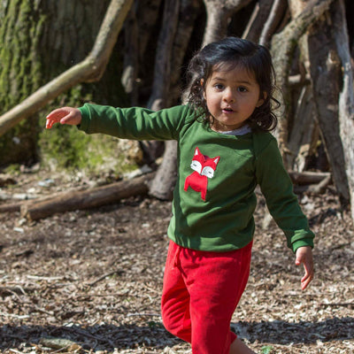 bambina indossa maglietta a maniche lunghe verde con volpe applicata e pantaloni rossi